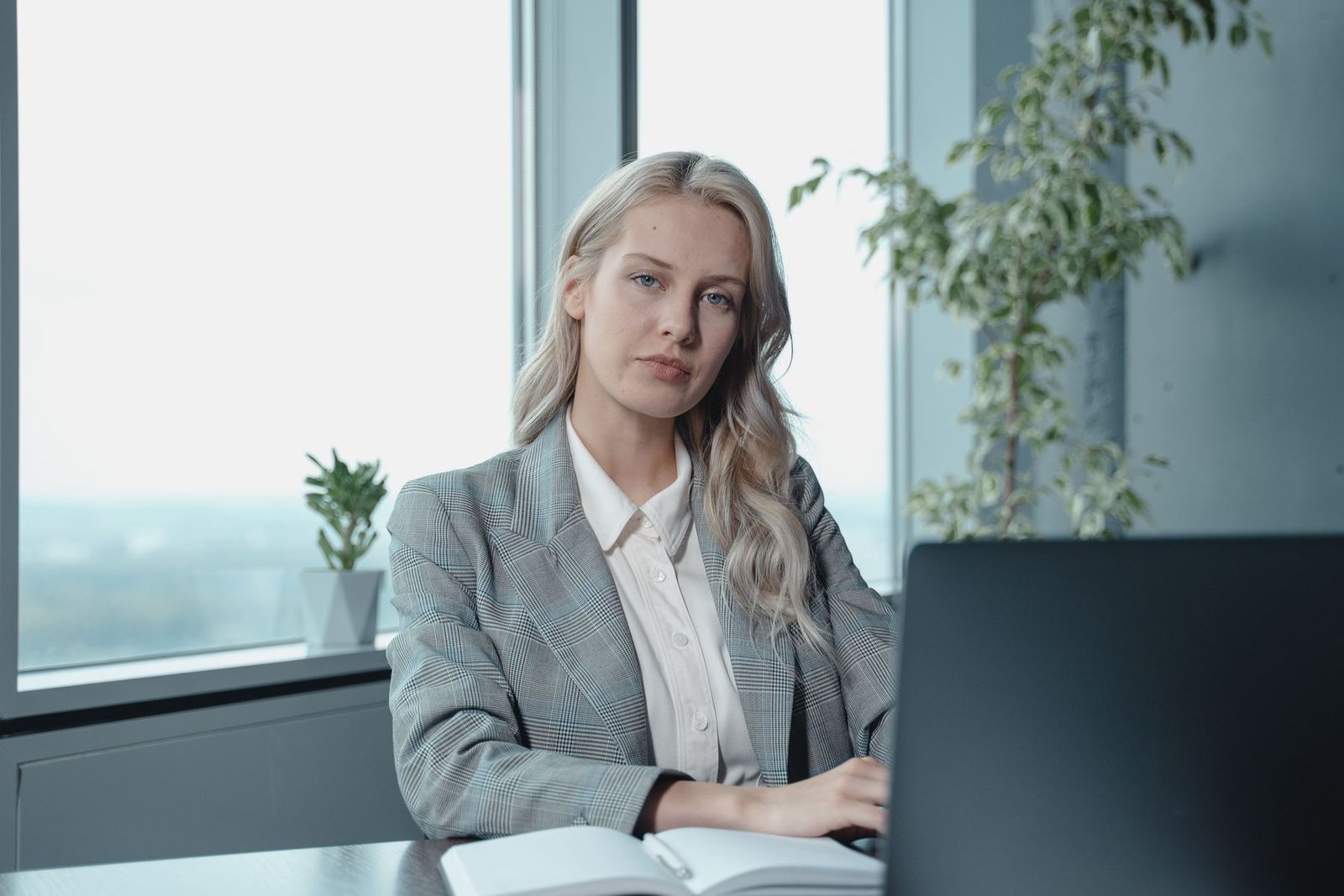 Une dirigeante à son bureau, face à son ordinateur, regard assuré